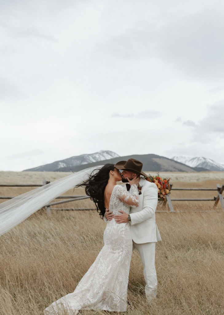 Couple kissing in Jackson Hole while bride is glowing from her spray tan