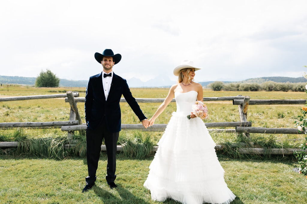 Newlyweds eloping in Jackson Hole in a wide open field with mountains in the background