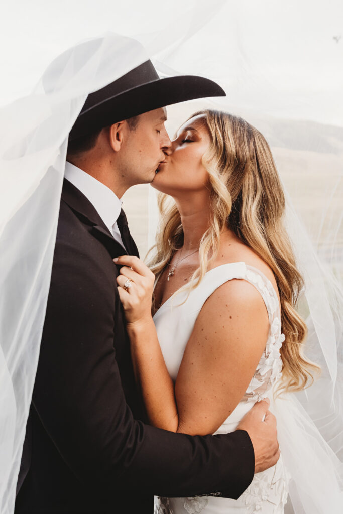 Newlyweds kissing at their mountain wedding